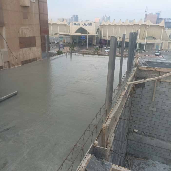 سقف خرساني مصبوب حديثاً مع أشاير حديد التسليح في موقع بناء